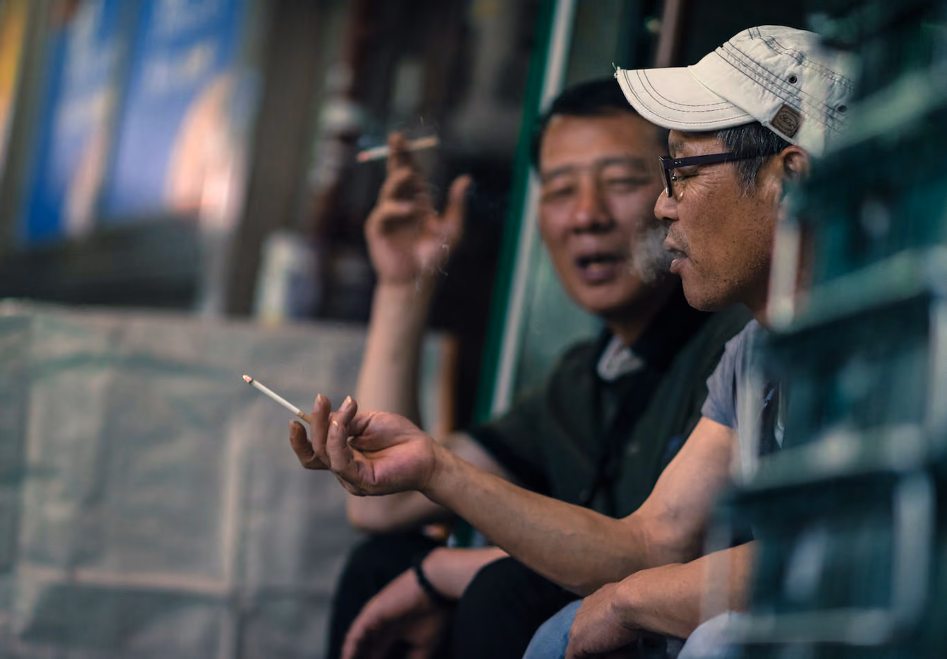 Two men talk and smoke at night in Seoul